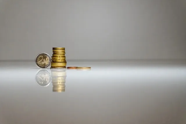 Une pile de pièces de monnaie posée sur une surface réfléchissante photo